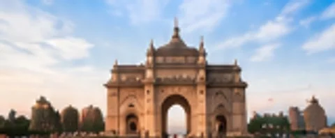 Historic sandstone gateway monument in India under a blue sky